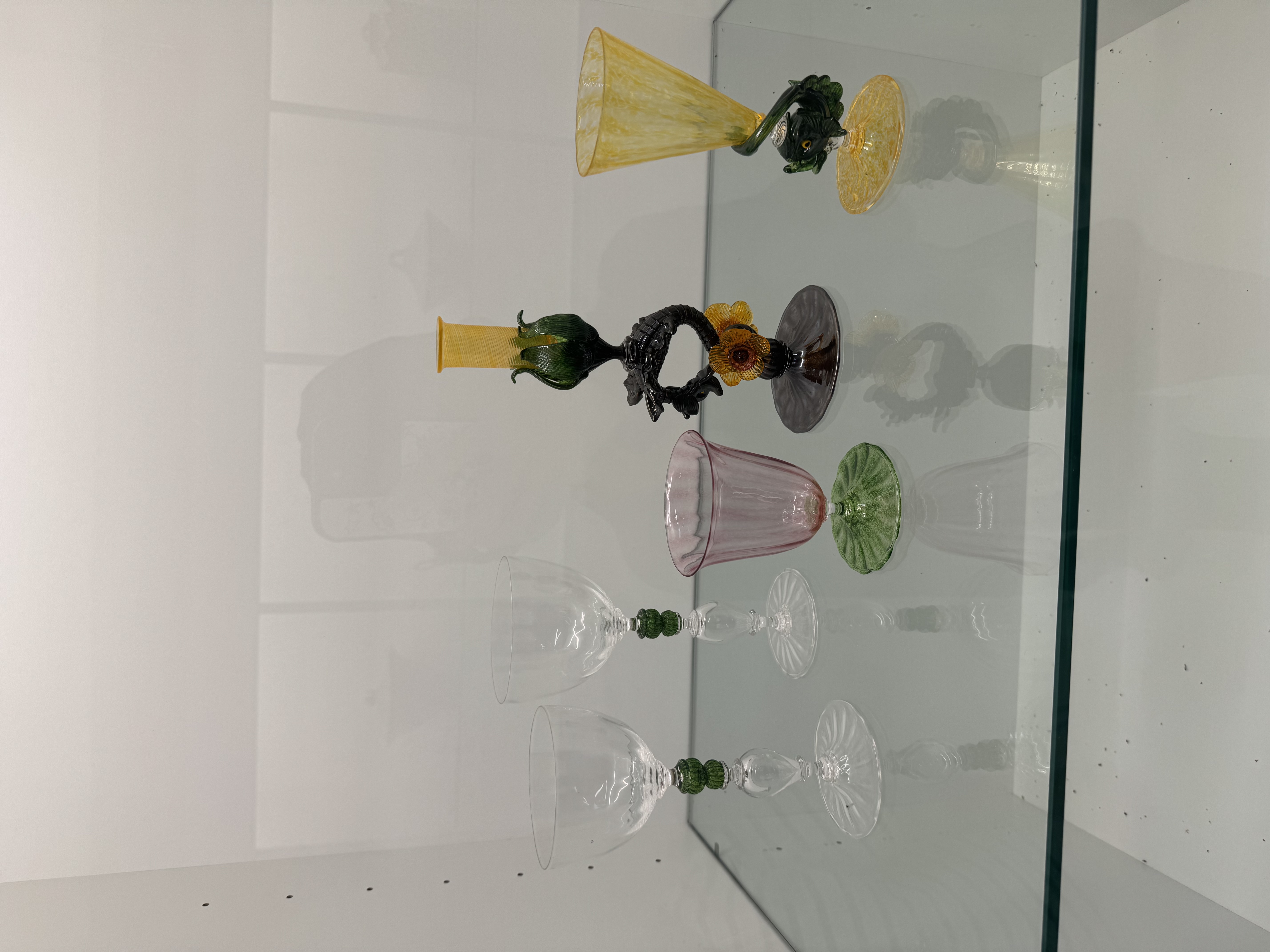 These items are translucent, colorful, detailed, and have a smooth surface. They appear to be glass, probably blown glass or handcrafted art glass. They are typical of decorative colored glass craftsmanship.